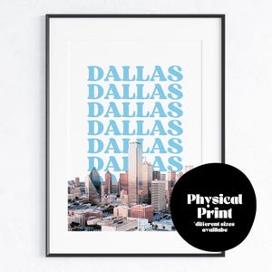 May include: A print featuring a skyline of Dallas, Texas with the word "Dallas" repeated in a light blue color. The print is framed in a black frame and has a black circle with the text "Physical Print" and "different sizes available" in white text.