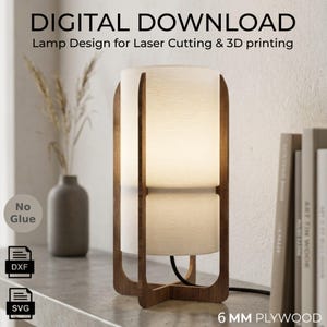 May include: A cylindrical table lamp with a dark wood frame and a white textured shade. The text reads: DIGITAL DOWNLOAD, Lamp Design for Laser Cutting & 3D printing, No Glue, DXF, SVG, 6 MM PLYWOOD. The lamp emits a soft warm light.