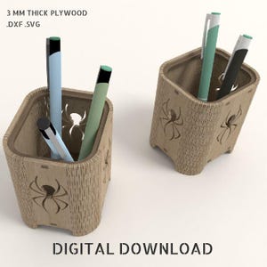 May include: Two wooden pen holders with a spider design. Each holder contains pens in various colors. The text "3 MM THICK PLYWOOD .DXF .SVG" and "DIGITAL DOWNLOAD" are visible.