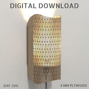 Puede incluir: Aplique de pared de madera con un diseño ranurado, iluminado desde el interior. El aplique está hecho de contrachapado de 4 mm y está montado en una pared blanca. El texto "DESCARGA DIGITAL" y ".DXF .SVG" son visibles.