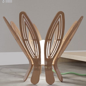 Puede incluir: Una lámpara de madera con un diseño de flor. La lámpara está hecha de madera de 3 mm de grosor y tiene una bombilla blanca. La lámpara está sobre un suelo de baldosas grises. El texto "DIGITAL DOWNLOAD .DXF .SVG 3 mm" es visible en las esquinas superior izquierda y derecha de la imagen.