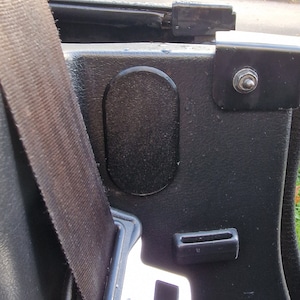 Peut inclure: Ceinture de sécurité de voiture noire avec une boucle argentée et un cache en plastique noir. La ceinture de sécurité est attachée à un intérieur de voiture noir.