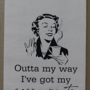 May include: A white tea towel with a black and white illustration of a woman holding a cup of coffee. The text "Outta my way I've got my sassy pants on today." is printed below the illustration.