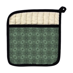 May include: Green and black pot holder with a clover pattern. The pot holder has a white terry cloth lining.
