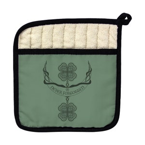 May include: Green pot holder with a black border and a white quilted top. The front features a stylized design of two four-leaf clovers with the text "Never Forgotten" in a circular banner.