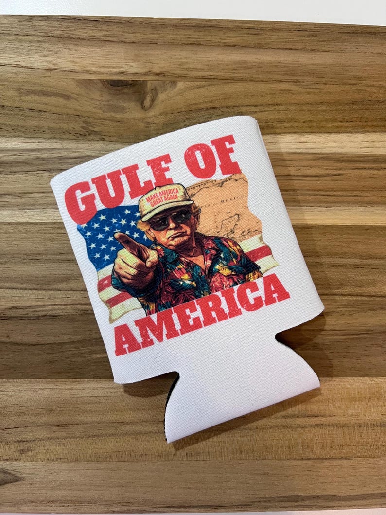 以下が含まれることがあります： 「GULF OF AMERICA」の赤い文字が入った白い缶クーラー。デザインは、アメリカの国旗と地図とともに、指をさしている男性が特徴です。「MAKE AMERICA GREAT AGAIN」と書かれた帽子をかぶっています。
