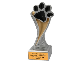 Può includere: Trofeo d'argento con un'impronta di zampa nera in cima. La base è argentata con una placca dorata su cui è scritto "Your Text Here Example - Example Best Team #1 2002".