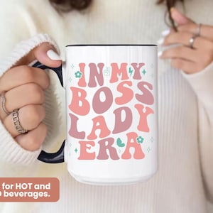 May include: White ceramic mug with a pink, green and blue design that says "In My Boss Lady Era".
