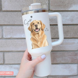 May include: White insulated tumbler with a handle, featuring a golden retriever illustration, paw print, and hearts. The name "Susi" is written in cursive. The tumbler has a silver rim and a clear lid.