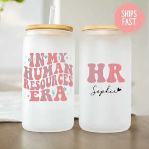 May include: Two frosted glass tumblers with bamboo lids. One tumbler reads "IN MY HUMAN RESOURCES ERA" in pink and red retro font. The other reads "HR Sophie" in pink and black font. Both have a straw.