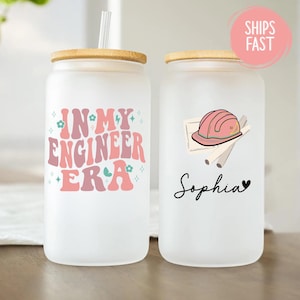 May include: Two frosted glass tumblers with bamboo lids. One features the text "IN MY ENGINEER ERA" in pink and peach tones. The other has a pink hard hat graphic, blueprints, and the name "Sophia" in script.