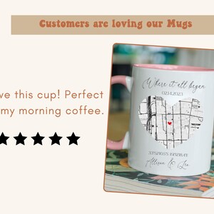 May include: White ceramic mug with a pink rim. The mug has a black and white map design with a red heart in the center. The text "Where it all began" and "0214.2023" is printed on the mug. The text "33521055 15727847 Allison & Le" is printed on the bottom of the mug.