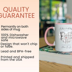 May include: White ceramic mug with a pink handle. The mug has a black and white map design with a red heart in the center. The text "Where it all began" is printed above the map. The text "02.14.2023" is printed below the map. The text "Atwood, Nebraska" is printed below the date. The text "Allison & Lee" is printed below the location.