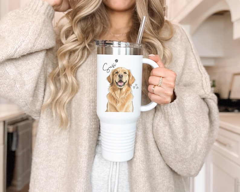 May include: White insulated tumbler with a handle and a silver lid. The tumbler features a watercolor illustration of a golden retriever, the name "Suzi" in script, and paw prints and hearts.