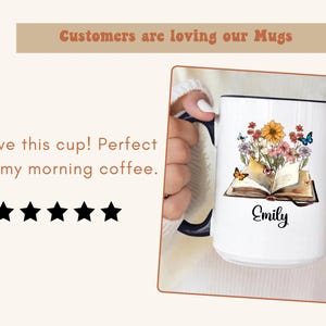 May include: White ceramic mug with a black rim, featuring a floral and butterfly design over an open book. The name "Emily" is written in cursive. Text at the top reads "Customers are loving our Mugs."
