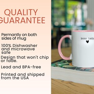 Pu&ograve; includere: Tazza in ceramica bianca con interno e manico rosa. La tazza presenta il testo "boss lady" con un piccolo cuore nero. L'immagine include anche il testo "QUALITY GUARANTEE" e altri dettagli del prodotto.