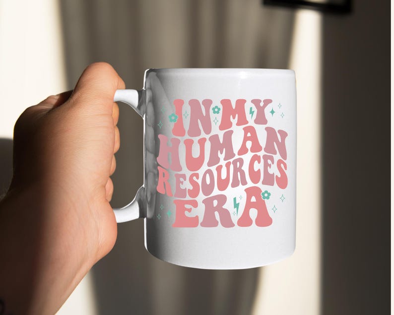 May include: White ceramic mug with a pink and blue design that says "In My Human Resources Era".