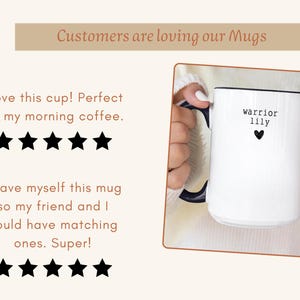 Pu&ograve; includere: Una tazza di ceramica bianca con interno e manico neri. La tazza presenta le parole "warrior lily" e un piccolo cuore nero. L'immagine include anche il testo "Customers are loving our Mugs".