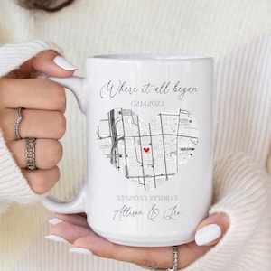 May include: White ceramic mug with a black and white map of a city in the shape of a heart. The text "Where it all began" is at the top of the mug, with the date "02142023" below it. The coordinates "33°52'10.5"S 151°12'18.4"E" are printed below the map, along with the names "Allison & Lee".