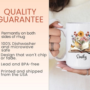 May include: White ceramic mug featuring a floral and butterfly design over an open book. The mug has the name "Emily" printed on it. The text "QUALITY GUARANTEE" is visible in the image.