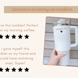 May include: White tumbler with a handle, a lid, and the text "chapter 30" with a heart symbol. The tumbler is held by a person. The image also includes the text "Customers are loving our tumblers".