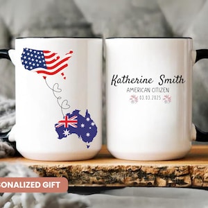 May include: White ceramic mug with a black handle and rim. The mug features a map of the USA and Australia connected by hearts, with the text "Katherine Smith, American Citizen, 03.03.2025". The mug is a personalized gift.