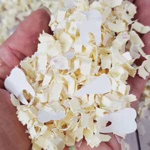 May include: A handful of white confetti with tooth shapes. The confetti is made of paper and is perfect for a party or celebration.