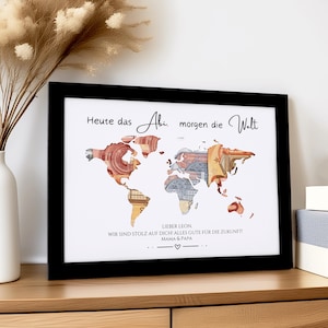 Könnte beinhalten: Ein gerahmter Kunstdruck mit einer Weltkarte aus bunten Geldscheinen, in einem schwarzen Rahmen. Der Text lautet "Heute das Abi, morgen die Welt" mit einer persönlichen Nachricht darunter.