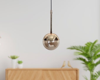 Suspension simple globe en verre ambré avec détails dorés et noirs, éclairage de plafond moderne et élégant pour une décoration intérieure raffinée