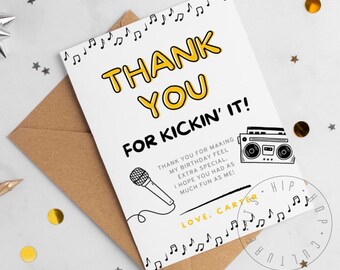 May include: A white thank you card with black and yellow text that reads "Thank You for Kickin' It!"  The card features a black and white illustration of a microphone and a boombox. The text "Love, Carter" is written in black and yellow. The card is decorated with black musical notes.