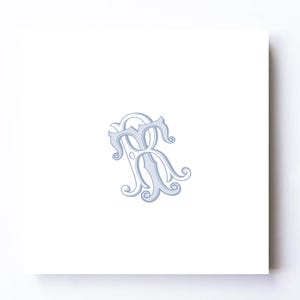 May include: A light blue monogram design featuring the letters "TR" intertwined with ornate, swirling details. The design is centered on a white background, creating a classic and elegant aesthetic. The letters are in a serif font.