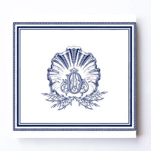 May include: A square white card featuring a dark blue rope-style border. In the center, a detailed dark blue illustration of a scallop shell sits above a coral branch. Overlaid on the shell is an ornate, stylized monogram letter O in dark blue.