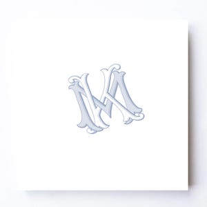 May include: A square white card featuring a centered, stylized monogram of the letters M and A intertwined. The letters are rendered in a light periwinkle blue with a darker blue outline and shadow effect, creating a layered, dimensional appearance.