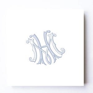 May include: A square white card features a light blue and gray monogram design. The intertwined letters, possibly "H" and "M", are rendered in an ornate, elegant script with decorative flourishes. The card is set against a white background.