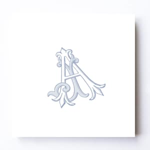 May include: A light blue, ornate letter "A" with decorative flourishes. The design is centered on a white background, creating a classic and elegant aesthetic. The letter is in a serif font.