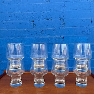 May include: Set of five clear glass drinking glasses with a unique stacked design. Each glass has a wide, round base and a taller, narrower top section.