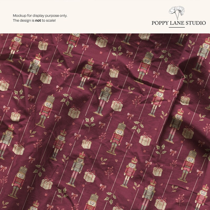May include: Burgundy fabric with a repeating pattern of nutcrackers, wrapped gifts, bows, and sprigs. The nutcrackers are in red, gray, and gold. The gifts are wrapped in beige paper with a gold ribbon. The text "POPPY LANE STUDIO" is in the upper right corner.