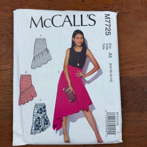May include: A McCall's M7725 sewing pattern envelope for a skirt with an asymmetrical hemline. The front shows four variations: a solid skirt, a red and white gingham check skirt, a blue floral print skirt, and a solid magenta skirt.