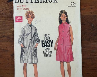 May include: A Butterick 5120 sewing pattern envelope featuring illustrations of two knee-length dresses with front pockets and button closures. One dress is white with black vertical stripes, and the other is solid pink. Text includes "ONLY FOUR EASY MAIN PATTERN PIECES" and "SIZE 10 BUST 32 1/2".