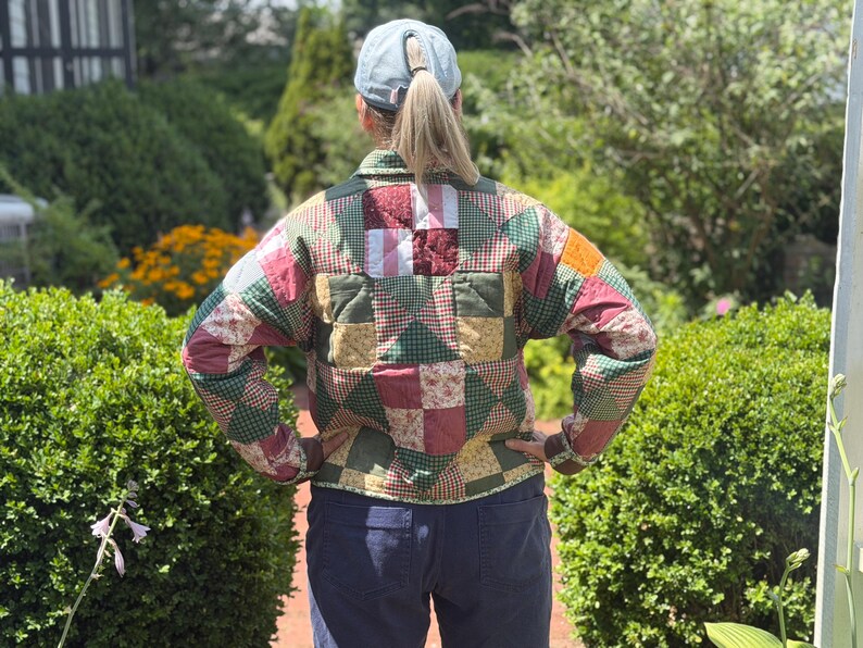 May include: A long-sleeved quilted jacket featuring a patchwork design composed of various fabric squares in shades of green, red, yellow, and white. The jacket has a collared neckline, a button-up front, and a multi-colored geometric pattern.