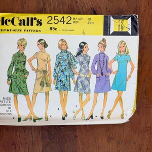 May include: Vintage McCall's sewing pattern for a Miss Petite Dress in six versions. The pattern envelope features illustrations of the dresses in various colors and patterns, including green, yellow, blue, and purple. The envelope is yellow and white.