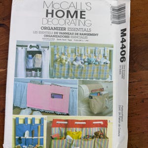 May include: McCall's Home Decorating Organizer Essentials pattern. The image shows various organizer designs, including hanging storage, pocket organizers, and a bed skirt with pockets. The pattern features text in English, French, and Spanish.