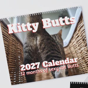 May include: A 2027 wall calendar titled Kitty Butts, featuring a photograph of a tabby cat standing in a wicker basket. The text reads Kitty Butts, 2027 Calendar, and 12 months of sexy cat Butts in white letters with a red outline on the cover.
