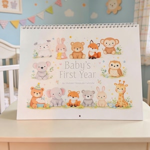 May include: A spiral-bound calendar titled "Baby's First Year" featuring illustrations of various animals, including a bear, fox, and giraffe. The calendar is displayed on a white surface in a nursery setting, with a crib and decorative elements in the background.