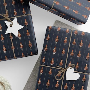 May include: Several wrapped gifts with navy blue paper featuring a repeating pattern of toy soldiers in red and gold. The gifts are tied with twine and have white star and heart-shaped tags.