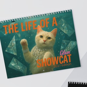 May include: A spiral-bound wall calendar featuring a cream-colored cat wearing a rhinestone necklace and bracelet. The background is a deep teal with floating diamond shapes and bubbles. The text reads THE LIFE OF A Glam SHOWCAT 2027 Edition.