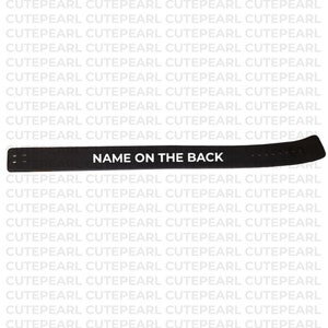 K&ouml;nnte beinhalten: Ein schwarzer Riemen mit dem Text "NAME ON THE BACK" in Wei&szlig;. Der Riemen hat eine gebogene Form und scheint aus einem strapazierf&auml;higen Material zu bestehen. Der Hintergrund zeigt ein sich wiederholendes Muster des Wortes "CUTEPEARL".
