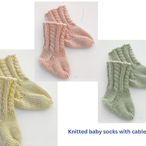 Peut inclure: Plusieurs paires de chaussettes pour bébés tricotées, aux couleurs pastel : rose pâle, vert clair et jaune pâle. Chaque paire présente un motif torsadé. Le texte "Knitted baby socks with cables" est visible.