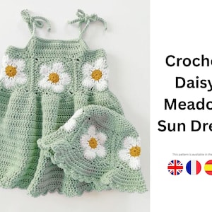 Puede incluir: Conjunto de vestido de sol y sombrero de ganchillo verde claro. El vestido y el sombrero presentan aplicaciones de margaritas blancas con centros amarillos. El texto de la imagen dice "Crochet Daisy Meadow Sun Dress".