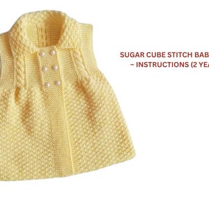 May include: A light yellow knitted baby vest with a collar and pearl-like buttons. The vest has a textured stitch pattern and cable knit detailing on the front. The text "SUGAR CUBE STITCH BABY VEST - INSTRUCTIONS (2 YEARS)" is visible.